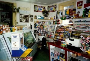 Dick Winking sitting on his stool in the store in 1996.