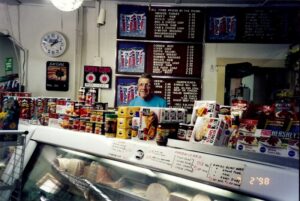 Dick Winking at the store on July 2, 1998 - 50 years in business and hard a work with a smile on his face.